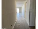 Spacious hallway showcasing new flooring and ample natural light from the sliding glass doors at the end at 18261 W Camino De Oro --, Surprise, AZ 85387