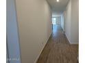 A hallway featuring wood-look tile flooring, neutral paint and leading to the living areas at 18261 W Camino De Oro --, Surprise, AZ 85387