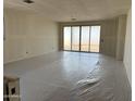 Bright living room featuring sliding glass doors leading to the outdoors with protective plastic on the floor at 18261 W Camino De Oro --, Surprise, AZ 85387