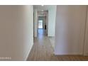 Bright hallway featuring ceramic wood-look tiling and neutral paint at 18265 W La Senda Dr, Surprise, AZ 85387