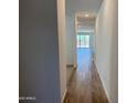 Hallway with attractive flooring leading to an open living area at 18271 W La Senda Dr, Surprise, AZ 85387