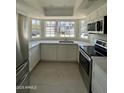 Modern kitchen with stainless steel appliances, white cabinets, quartz countertops, and a bay window at 18629 N 4Th Dr, Phoenix, AZ 85027