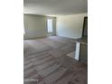Spacious living room with plush carpeting, large windows, and plenty of natural light at 18717 N 267Th Dr, Buckeye, AZ 85396