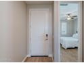 Bright hallway with wood floors leads to a bedroom featuring a ceiling fan at 20641 W College Dr, Buckeye, AZ 85396