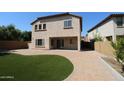 A backyard with a covered patio, a paved area, and artificial grass at 2213 W Marconi Ave, Phoenix, AZ 85023
