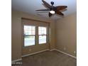 Neutral bedroom featuring a ceiling fan and natural light streaming through the windows at 2213 W Marconi Ave, Phoenix, AZ 85023