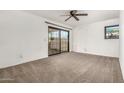 An empty bedroom with carpet flooring and sliding glass doors at 3208 W Port Royale Ln, Phoenix, AZ 85053