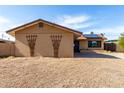 Tan home featuring a large lawn and charming architectural trellis at 3208 W Port Royale Ln, Phoenix, AZ 85053