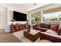 View of the spacious living room with ample light from windows and a large TV at 35990 N Desert Tea Dr, Queen Creek, AZ 85140