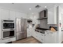 Modern kitchen with stainless steel appliances, gray backsplash and white cabinetry at 4117 E Coolidge St, Phoenix, AZ 85018
