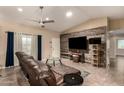 Inviting living room with a comfortable brown leather sofa and a stylish wood accent wall at 5127 E Tamblo Dr, Phoenix, AZ 85044