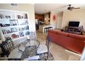 Charming dining area with a glass table, decorative shelving, and an open view into the kitchen at 5345 E Van Buren St # 115, Phoenix, AZ 85008
