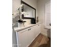 Coffee bar with sleek cabinets and a countertop featuring a mirror and floral arrangement at 5345 E Van Buren St # 216, Phoenix, AZ 85008