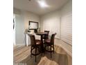 Cozy dining area with a wood table and four high-backed chairs near shuttered windows at 5345 E Van Buren St # 216, Phoenix, AZ 85008
