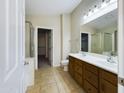 Bright bathroom featuring double sinks, wooden cabinets, tile flooring, and a separate toilet room at 8022 S 48Th Dr Dr, Laveen, AZ 85339