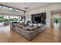 Open living room with a large sectional couch, a modern fireplace, and sliding glass doors to the backyard at 9148 N 66Th Pl, Paradise Valley, AZ 85253
