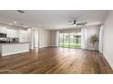 Open-concept living room featuring wood floors and sliding glass doors leading to the backyard at 9738 E Tumeric Ave, Mesa, AZ 85212
