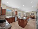 Gourmet kitchen with granite countertops, stainless steel appliances, and an island open to the living spaces at 981 N Quail Ln, Gilbert, AZ 85233