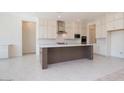 Spacious kitchen featuring white cabinets, a contrasting dark island and stainless steel appliances at 10013 S 36Th Ave, Laveen, AZ 85339