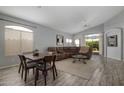 Open living room and dining area with wood floors, a brown couch, and lots of natural light at 10141 E Floriade Dr, Scottsdale, AZ 85260