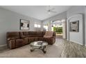 A spacious living room features a comfortable brown couch, a coffee table and lots of natural light at 10141 E Floriade Dr, Scottsdale, AZ 85260