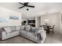 Comfortable living room featuring tile floors, a ceiling fan, and a large, plush sectional sofa at 1254 E Thomas Dr, Casa Grande, AZ 85122