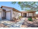 Attractive single-story home with a three-car garage, desert landscaping, and inviting entryway under a clear blue sky at 14938 W Mauna Loa Ln, Surprise, AZ 85379
