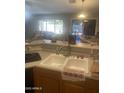 Kitchen featuring a double sink, decorative countertop items and a view to the backyard at 14938 W Mauna Loa Ln, Surprise, AZ 85379
