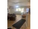 Spacious living room with plush seating, ceiling fan, and large windows for natural light at 14938 W Mauna Loa Ln, Surprise, AZ 85379
