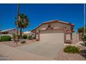 Inviting single-story home with a well-maintained front yard and a two-car garage at 17585 N Coyote Lakes Pkwy, Surprise, AZ 85378