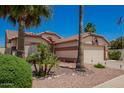 Beautiful exterior with mature palm trees, manicured landscaping, and a tiled roof at 17585 N Coyote Lakes Pkwy, Surprise, AZ 85378
