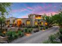 Beautiful stucco house with an arched doorway, desert landscaping, and terracotta roof at 19054 N 97Th Pl, Scottsdale, AZ 85255