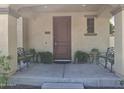 Covered front porch featuring seating and a dark wood door with address plaque at 21013 W Wycliff Dr, Buckeye, AZ 85396