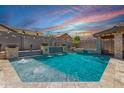 Amazing backyard pool with water feature, accent lighting, and travertine patio, perfect for relaxing and entertaining at 21275 E Russet Rd, Queen Creek, AZ 85142