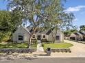 Stunning home with a manicured lawn, stone accents, mature trees, and a charming walkway to the front door at 325 W Solano Dr, Phoenix, AZ 85013