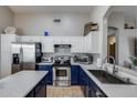 Well-lit kitchen features stainless steel appliances, blue bottom cabinets and white top cabinets at 363 W Bruce Ave, Gilbert, AZ 85233