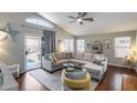 Bright living room with vaulted ceilings, wood floors, large sectional couch, and view to backyard at 363 W Bruce Ave, Gilbert, AZ 85233