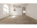 Spacious living room featuring neutral carpet, arched doorway, and ample natural light at 3646 E Rousay Dr, San Tan Valley, AZ 85140