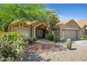 Inviting home showcasing lush desert landscaping, tile roof, and a covered front entrance at 4131 E Cascalote Dr, Cave Creek, AZ 85331