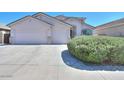 Well maintained single story home featuring a spacious three-car garage and desert landscaping at 43561 W Snow Dr, Maricopa, AZ 85138