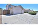 Single story home with a spacious two-car garage and gated parking area for additional vehicles at 43561 W Snow Dr, Maricopa, AZ 85138