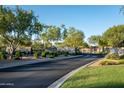 Community entrance gate with stone wall, lush landscaping, and paved road at 5434 E Barwick Dr, Cave Creek, AZ 85331