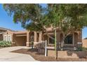 Charming home features a terracotta tile roof, arched entryway, and desert landscaping for a unique aesthetic at 5707 N Kristi Ln, Litchfield Park, AZ 85340
