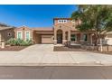 Beautiful two-story home showcasing a terracotta tile roof, arched entry, and mature desert landscaping at 5707 N Kristi Ln, Litchfield Park, AZ 85340