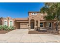Inviting two-story home with a terracotta-tiled roof, arched entry, and desert landscaping enhancing curb appeal at 5707 N Kristi Ln, Litchfield Park, AZ 85340