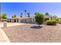 Charming single-story home featuring desert landscaping, covered porch, and shade awnings at 619 S Essex Ln, Mesa, AZ 85208