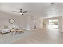 Bright living room with neutral decor, ceiling fan, and sliding glass doors to the backyard at 619 S Essex Ln, Mesa, AZ 85208