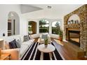 Bright living room featuring hardwood floors, a stone fireplace, and large windows with scenic views at 6255 S Opal Dr, Chandler, AZ 85249