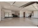 Spacious and organized three-car garage with ample storage space, workbench, and clean epoxy flooring at 682 W Gum Tree Ave, Queen Creek, AZ 85140