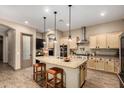 Spacious kitchen featuring a large island with granite countertop, stainless steel appliances, and modern lighting fixtures at 682 W Gum Tree Ave, Queen Creek, AZ 85140